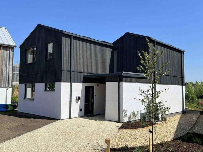 Dark clad home with rendered base